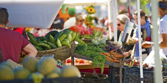 fruits and vegetables on a table at an outdoor farm market