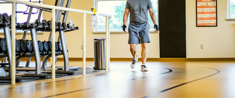 A man walks on an indoor track.