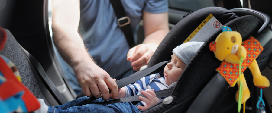 A baby gets tucked safely into its car seat.