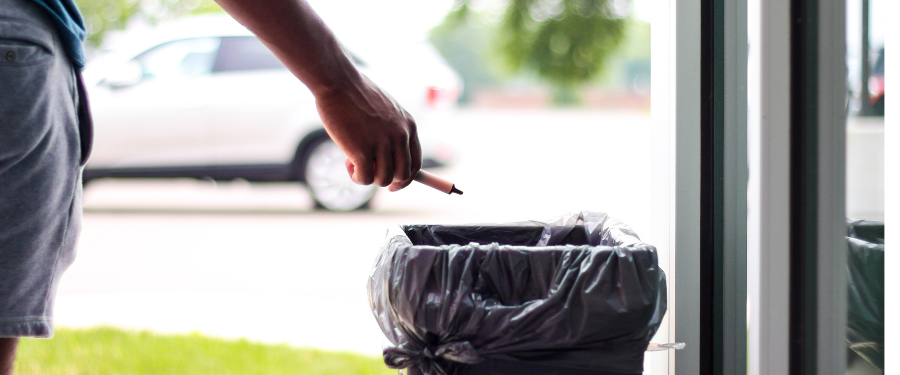 Male throws away an electronic vapor product in the garbage 