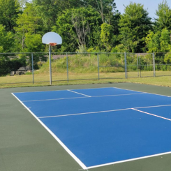 Blue flooring under an outdoor basketball court