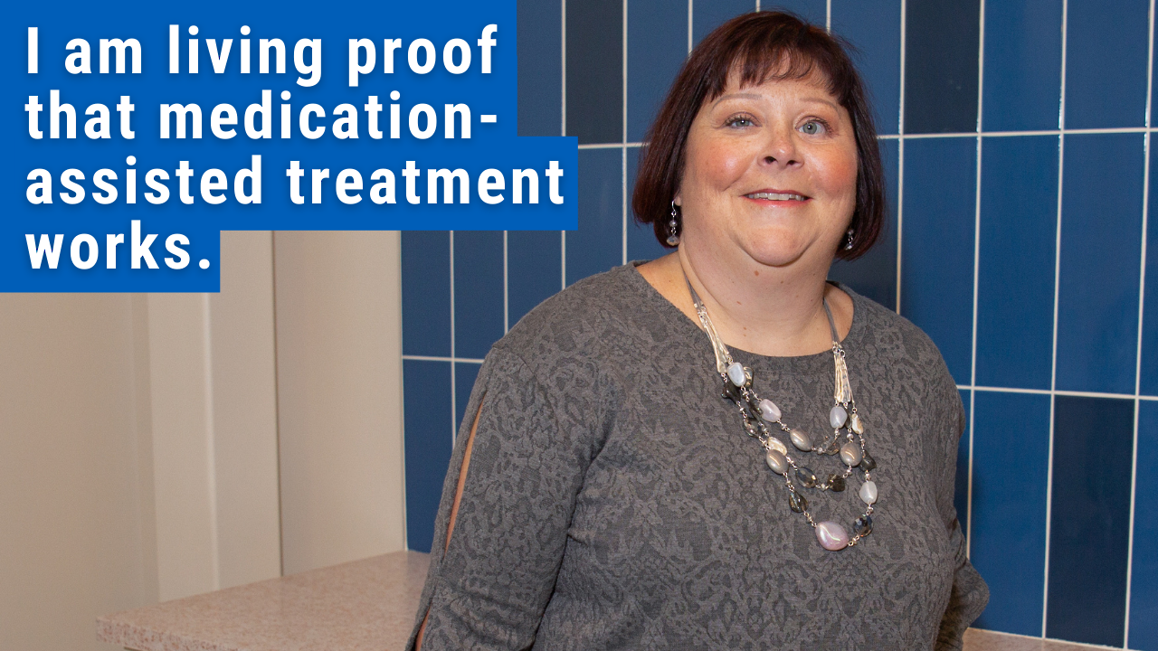 woman standing smiling with text "i am living proof that medication-assisted treatment works" 