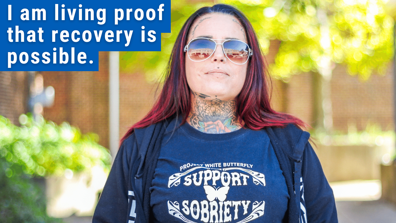 woman standing with text "i am living proof recovery is possible"