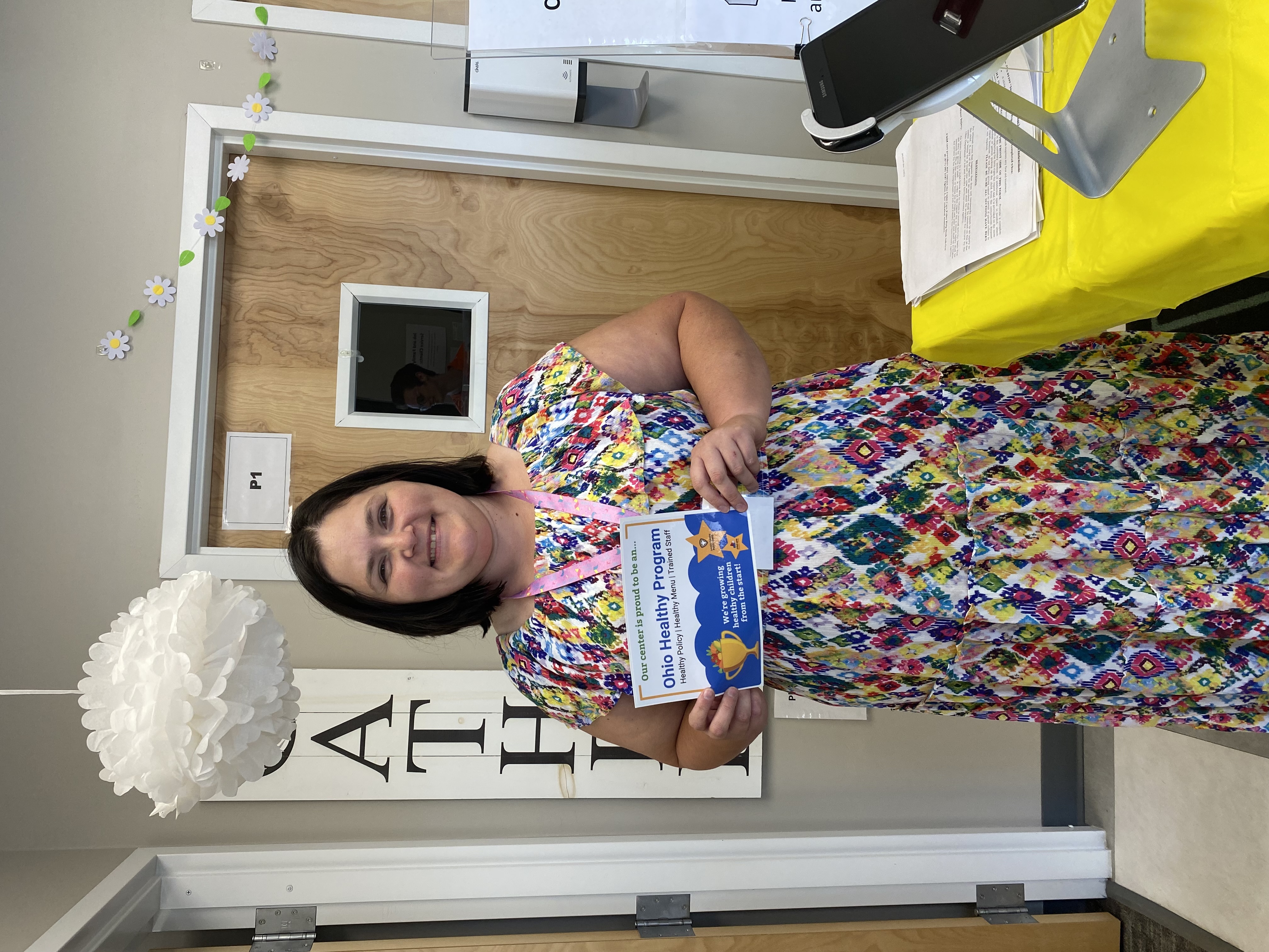 childcare director standing with ohio healthy programs designation sign 